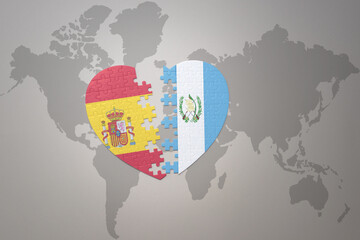 puzzle heart with the national flag of guatemala and spain on a world map background. Concept.