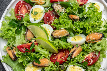 Fresh salad with mussels, quail, egg, conjugate, lime, spinach, lettuce, cherry tomatoes and microgreen. Dietary salad. banner, menu, recipe place for text, top view