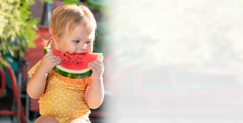 Banner of happy childhood. Portrait of a cute Caucasian little girl eating a slice of fresh...