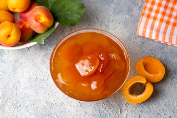 Apricot fruits and apricot jam on the wooden background