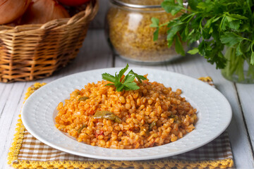 Traditional turkish bulgur pilaf with tomato sause in plate (Turkish name; meyhane pilavi)