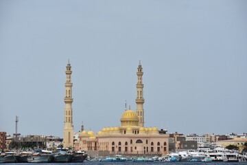 Fototapeta na wymiar View of the coastline with the Mosque El Mina Masjid, yachts and buildings, in New Marina in Hurghada, Egypt.