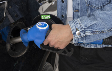 main de femme en train de faire le plein d'éthanol