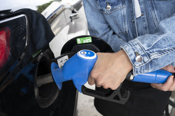 main de femme en train de faire le plein d'éthanol