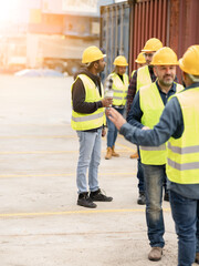 Fototapeta na wymiar group of logistics workers in port with containers talking before work time - focus on Indian man -