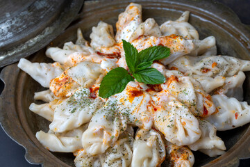 Traditional manti food on plate, top view. The concept of oriental cuisine. Uzbek food manty dumplings. (Turkish name; hinkel mantisi)