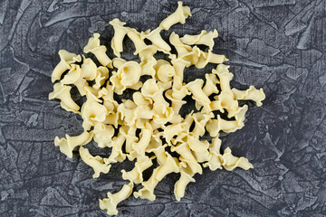 Raw dry campanelle pasta on a black background.