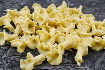 Raw dry pasta campanelle from durum wheat close-up.
