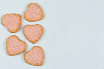 Heart-shaped butter cookies close-up on a concrete gray background with space for text.