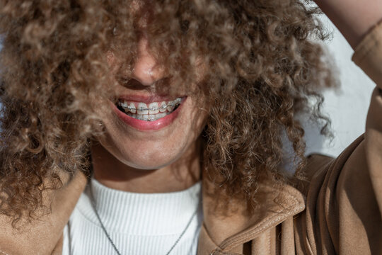 Cheerful Woman With Curly Hair And Braces