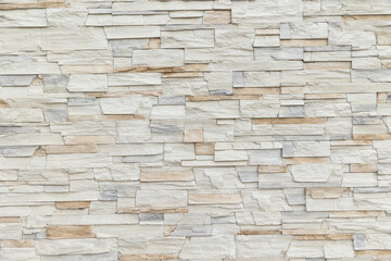 wall of white and beige sandstone bricks. Stone wallpaper, background and decor concept