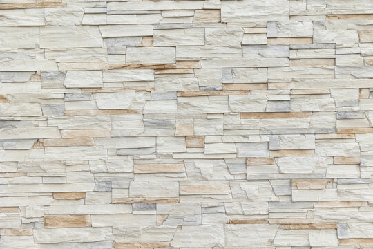 wall of white and beige sandstone bricks. Stone wallpaper, background and decor concept