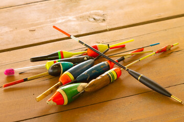 fishing floats, on the background of a wooden table close-up, top view, selective focus. Fishing concept. © maltsev_em