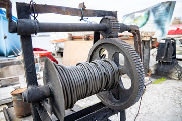 Winch with a rope on a pier with boats and boats against the sky