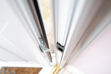 Very shallow focus of the locking system seen on a newly installed PVC double glazed door.  The brass runner can be seen on the bottom, leading to a patio area.