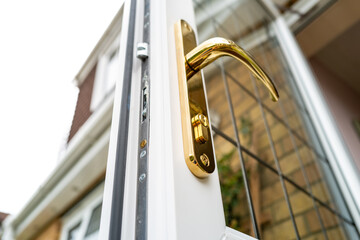 Shallow focus of a generic brass coloured door lock seen on a newly installed double glazed and...