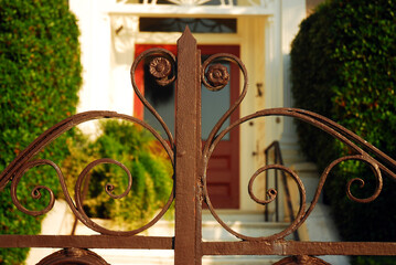 Details of a decorative wrought iron gate on a surrounding fence of an Antebellum manor in  ...