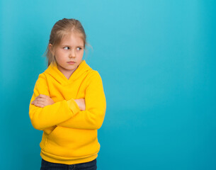 Sad offended little girl with arms crossed looking aside to copy space.