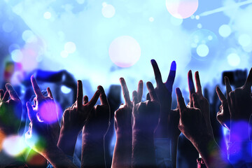 Fototapeta na wymiar Crowd fans hand silhouettes at rock pop concert, party, event. Abstract blurred background. Many arms of people having fun