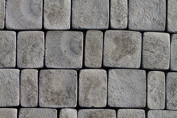 Gray tiles on the sidewalk are laid out around the circumference