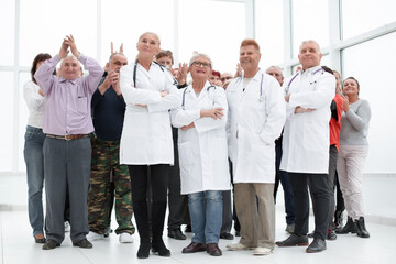 a group of senior citizens and doctors in full growth put a hand - obrazy, fototapety, plakaty