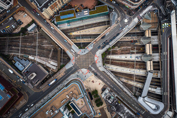 Aerial top down view of a road and railway junction in a bustling city