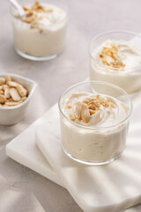 Creamy dairy yoghurt dessert with mascarpone, cream cheese and peanut butter in glasses on marble tray