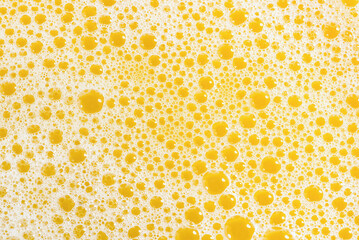 Closeup of orange juice foam, top view. Splash of fresh sweet orange, mango, fruit juice. Freeze motion of pouring orange juice .