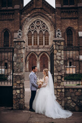 Obraz premium Beautiful newlywed couple standing near old christian church