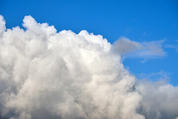 Naklejka na ściany i meble Bright landscape of white puffy cumulus clouds on blue clear sky