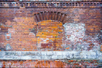 Texture. Old brick wall with a laid window and traces of paint and concrete
