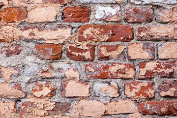 Old wall of chipped bricks
