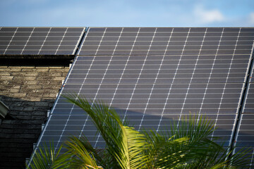 Obraz premium Private home roof covered with solar photovoltaic panels for generating of clean ecological electric energy in suburban rural town area. Concept of autonomous house