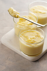 Creamy french vanilla pudding in glass on marble board on grey neutral background