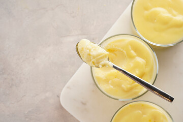 Creamy french vanilla pudding in glass on marble board on grey neutral background