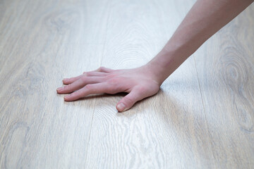 Underfloor heating in the apartment.A person touches..the warm floor with his hands.