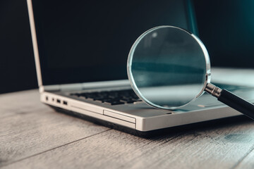 Magnifying glass on laptop computer