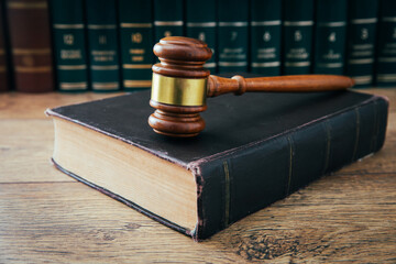 Wooden gavel and books on wooden table