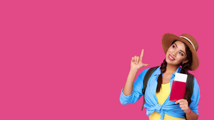 Fototapeta na wymiar Young female traveler in straw hat holding passport with airplane tickets and point index finger up on vivid pink isolated background. Woman european hipster or smiling student. Tourism concept