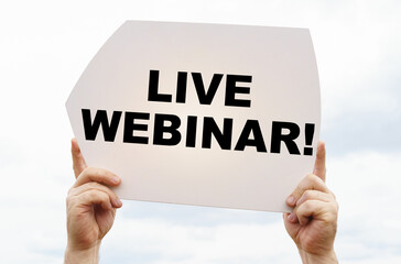 Against the background of the sky in the hands of a man is a sign with the inscription - Live Webinar