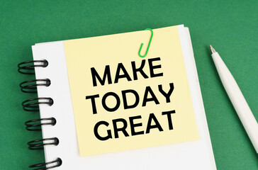 On a green surface, a pen, a notepad with stickers and the inscription - Make Today great © Dzmitry