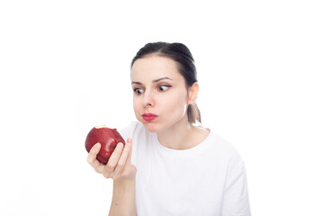 woman in white t-shirt eating red apple, white studio background