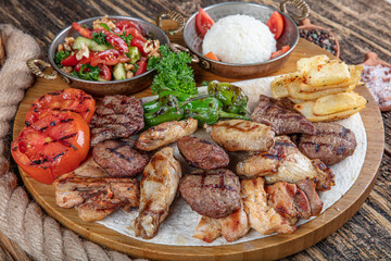 Turkish cuisine, mixed kebab. Meat platter fried on charcoal with spices on a wooden board. Rack of...
