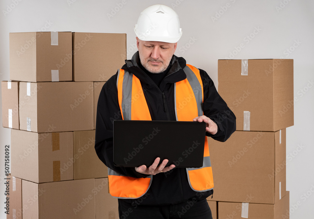 Aufkleber warehouse manager. man with laptop in front of boxes. warehouse manager in protective hard hat. huma