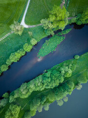 Aerial photo of slow river, trees and road.