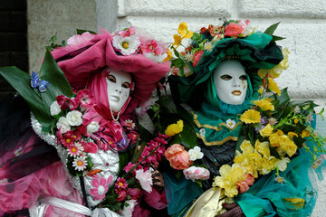 Venise, Italy, 28 février 2012 : Deux personnes déguisées et recouverte de fleurs, au couleur rose, vert, jaune