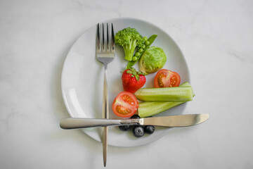 Vegetables and fruits on a plate on a light background