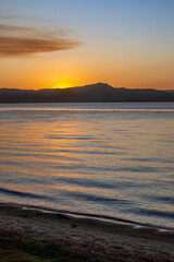 Obraz premium View of the sunset on the sea in Florianopolis in southern Brazil. Boardwalk by the sea. Nature. Rocks on the sea. Mountains.