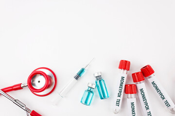 Blood sample tube for Monkeypox virus test, stethoscope and syringe with vaccine form pox on white background. Medical concept. Top view.