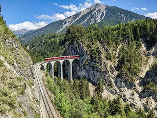 Wall murals Landwasser Viaduct Landwasser viaduct in the Davos mountains near Filisur. Beautiful old stone bridge with a moving train. Spring Time